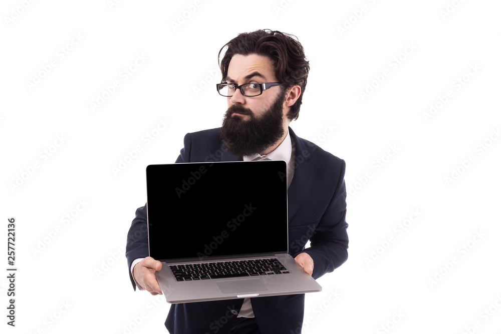 Frowning bearded businessman with a laptop in hand, raising an eyebrow looking at the camera, isolated on white background Frowning bearded businessman with a laptop in hand, raising an eyebrow looking at the camera, isolated on white background