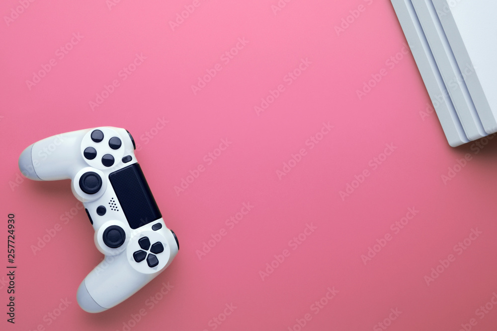 Computer gaming. Gaming concept. White joystick and conor of gamepad console on pink background. Computer gaming. Gaming concept. White joystick and conor of gamepad console on pink background.
