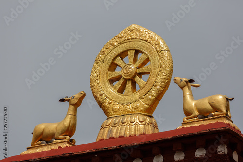 LHASA, TIBET / CHINA - July 30, 2017: Close up of Dharma Wheel and Deers on top of Jokhang Temple. Dharmachakra, golden, holy, spiritual, sacred, Dalai Lama, buddishm, pilgrims.