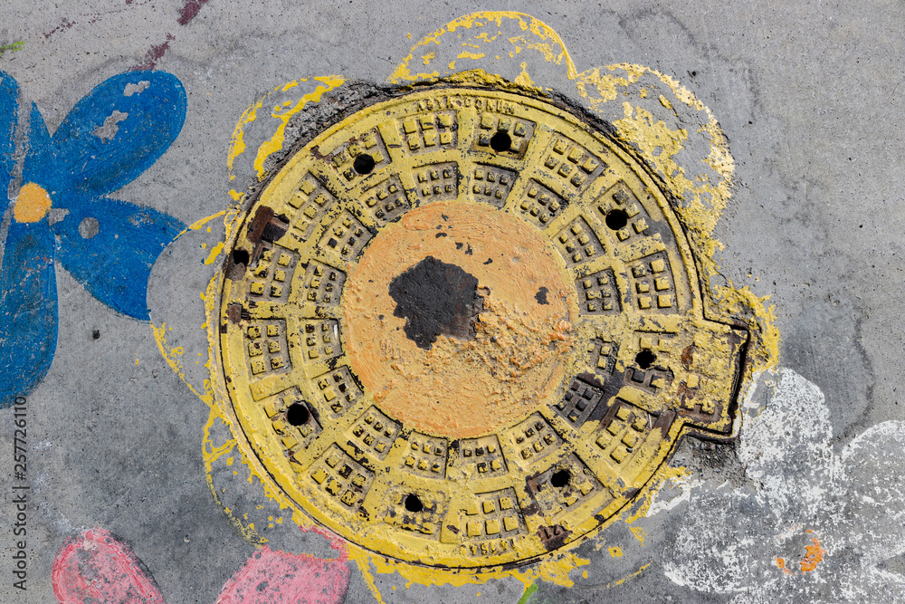 Colorful sewer hatch cover on the road