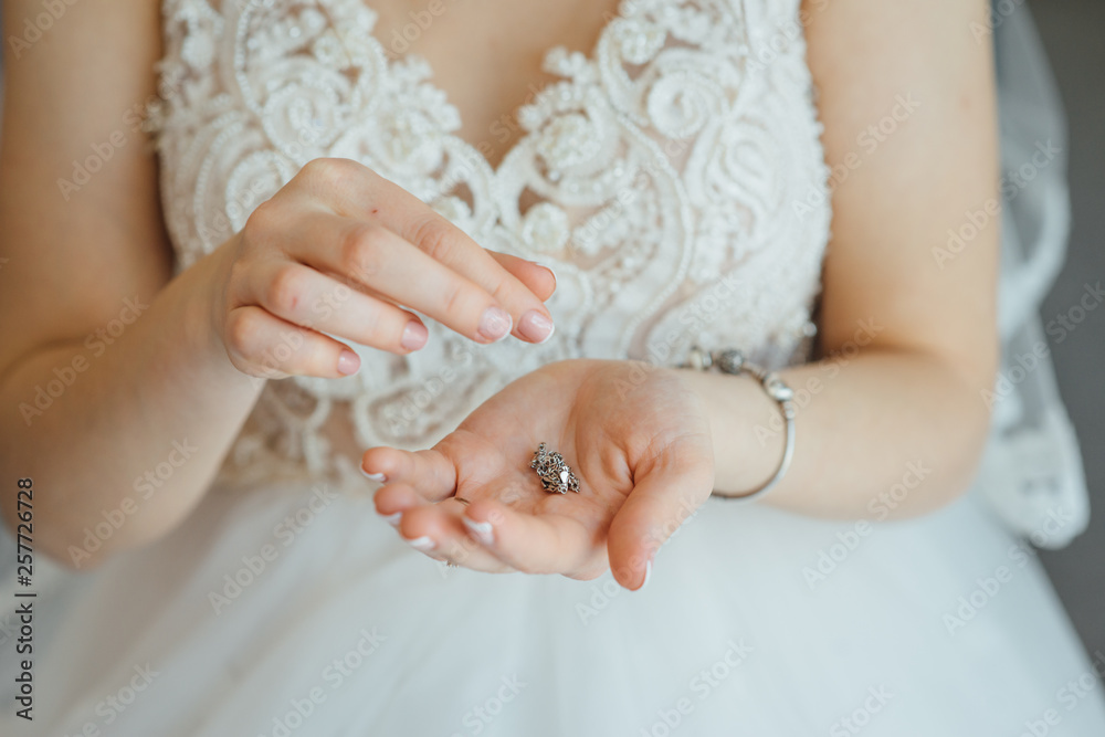 beautiful bride holding a necklace in her hands