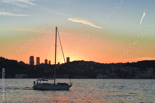 sailing boat passing through Istanbul Strait. sailing past sunset