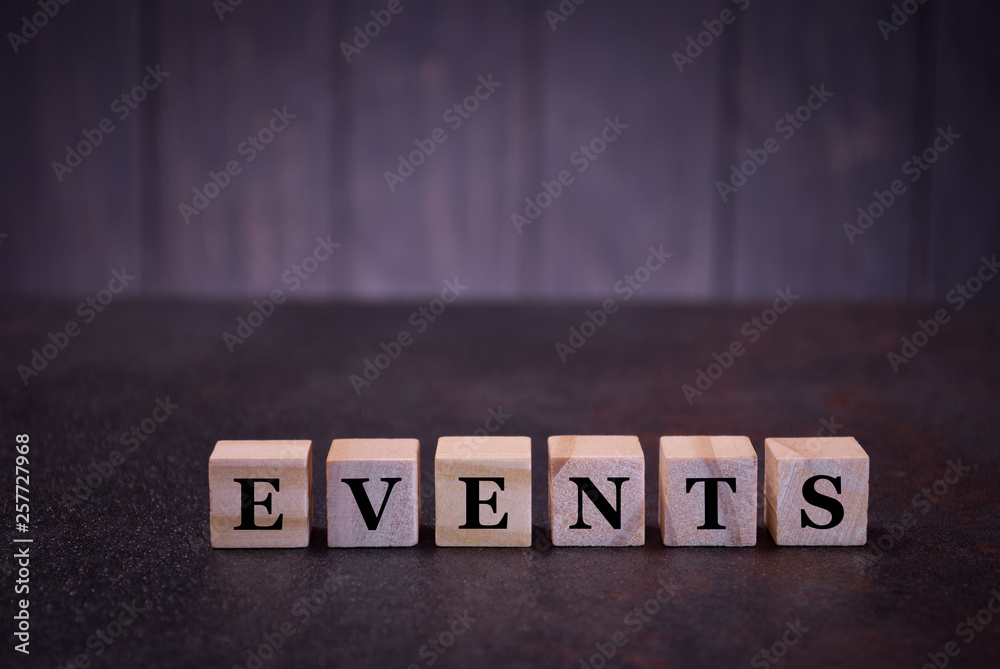 Obraz premium The word events on wooden cubes, on a dark background, symbols signs