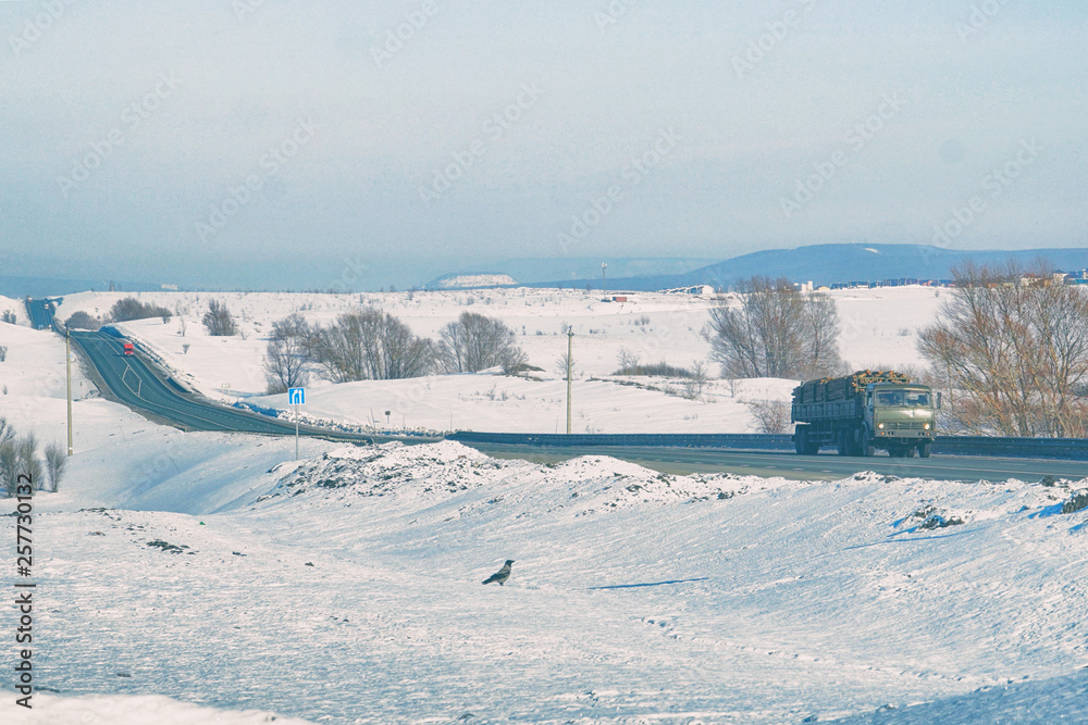 Obraz premium Truck rides on the highway on Sunny winter day