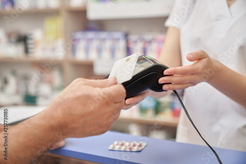 Credit card payment for pills with terminal in pharmacy.