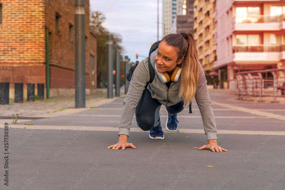 An athletic woman stretching on the street An athletic woman stretching on the street