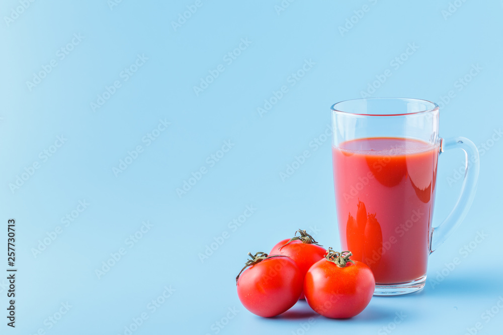 Fresh tomatoes and a glass full of tomato juice Fresh tomatoes and a glass full of tomato juice