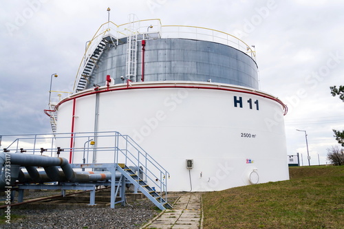 Liquid and fluid gas or oil storage tank, holder, container, dramatic sky background copy space photo