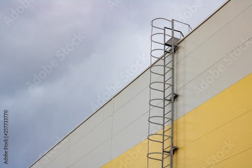 Ladder to the roof of a tall building on a dark sky background photo