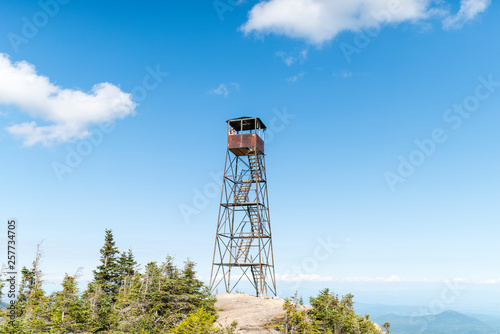 a woman and an old fire tower a top of a mountain
