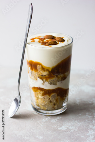 Dessert bowl with tasty caramel parfait on table.