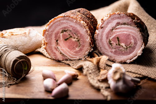 Roulade of bacon with herbs and spices.