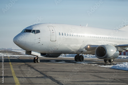 Passenger plane at airport in winter afternoon. plane on airport platform in winter. Airplane on summer strip in winter