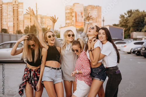 Six young women have fun at the car park.
