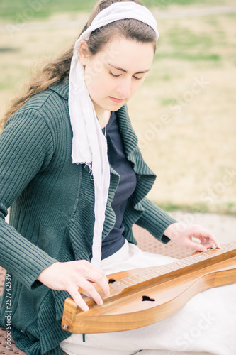Girl Sitting Playing Dulcimer