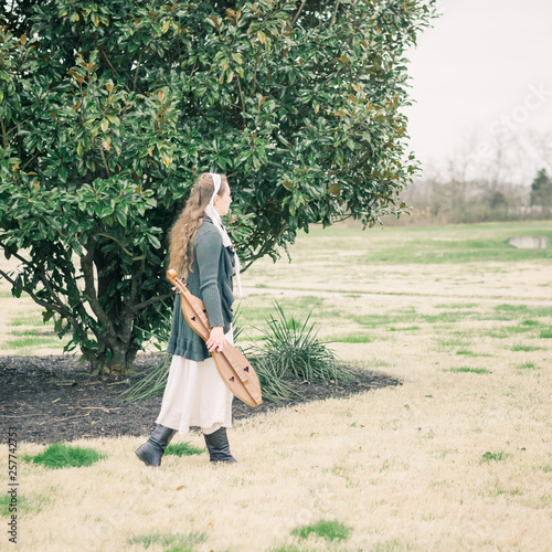 Girl Stepping Forward Carrying Dulcimer