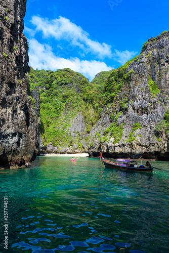 Wang Long Bay with crystal turquoise water, Tropical island Koh Phi Phi Don, Krabi Province, Thailand - Long boat in beautiful lagoon with rocks covered with a plants © Simon Dannhauer