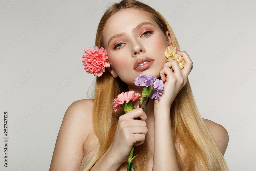 Playful and sexy portrait of pretty cheerful woman with spring flowers near her face Playful and sexy portrait of pretty cheerful woman with spring flowers near her face