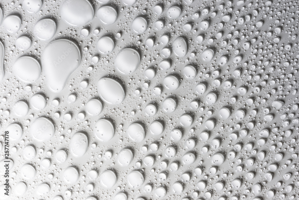 Droplets of water on a white, matte background illuminated with a delicate light. Droplets of water on a white, matte background illuminated with a delicate light.