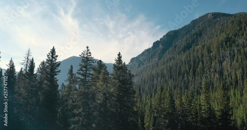 Aerial 4k footage flying through trees for a dramatic reveal into the forest of the Gallatin Mountains in rural Montana. photo