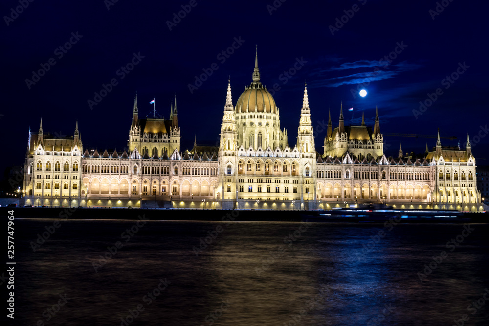 View of the Budapest Parliament at dusk with the Moon on its roofs at the blue hour, Hungary