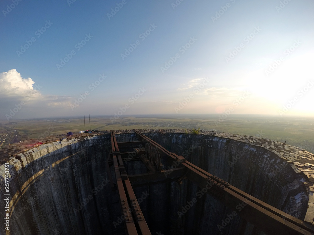 The picture was taken from the top of an abandoned industrial smoke chimney stack right after sunrise.