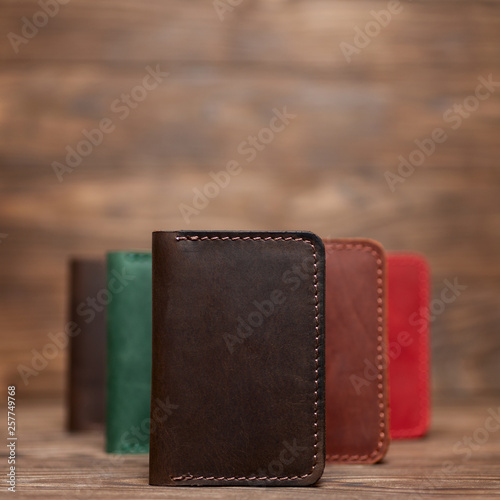 Soft focus photo of brown colour handmade leather cardholder. Blurred background on photo. Different colour cardholders blurred on background.