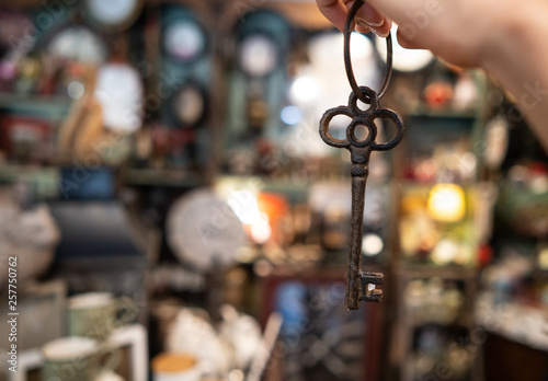 woman's hand holding an antique key on blurred background