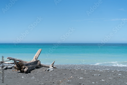 Stony beach with sea and blue sky beyond as scenic background image