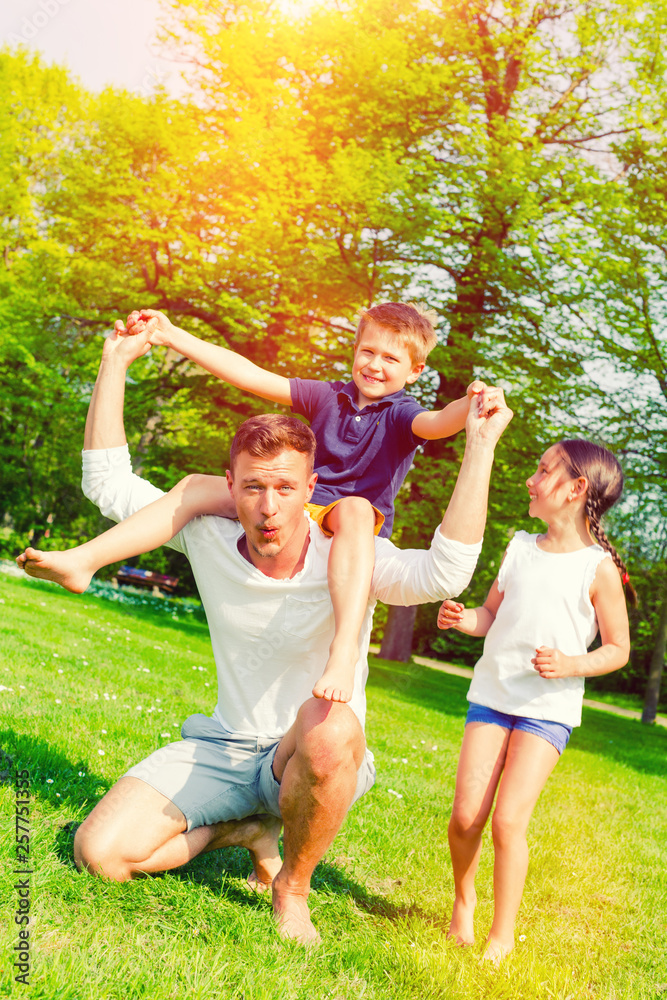 Happy young familiy daddy wih daughter and son in park 