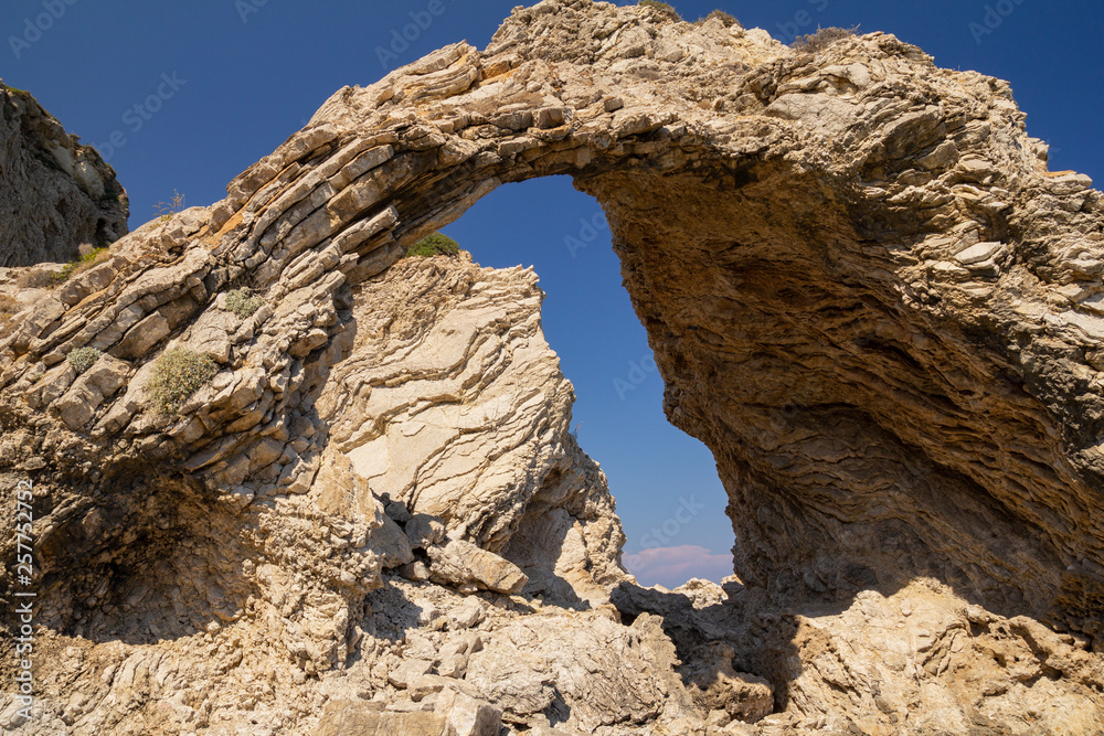 Natural arch on the Mediterranean coast. Rhodes Island, Greece.
