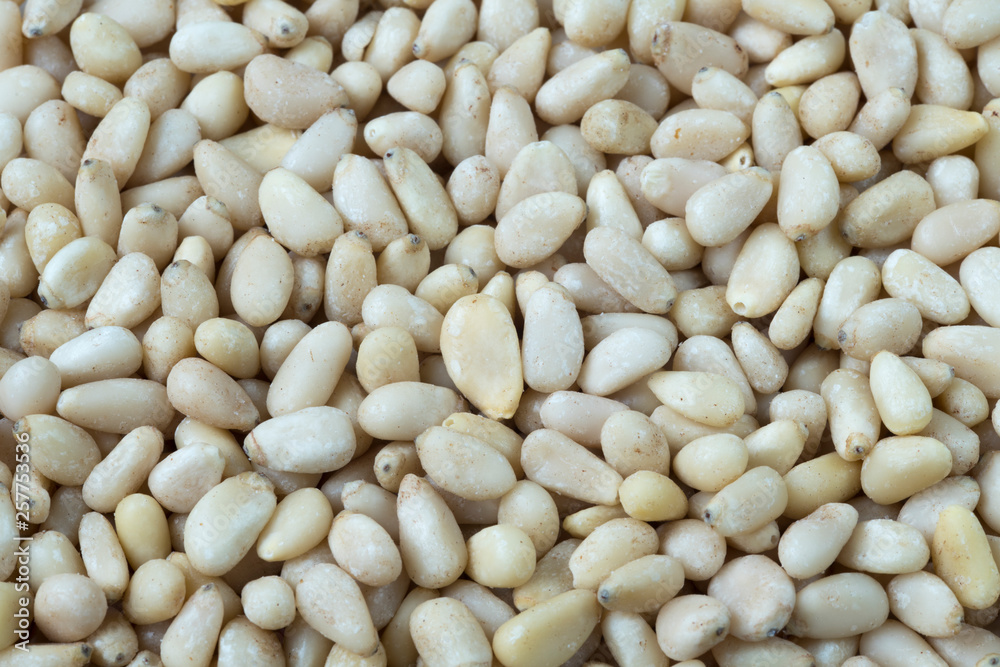 full screen of pignoli, pine nuts, close up. For background or texture