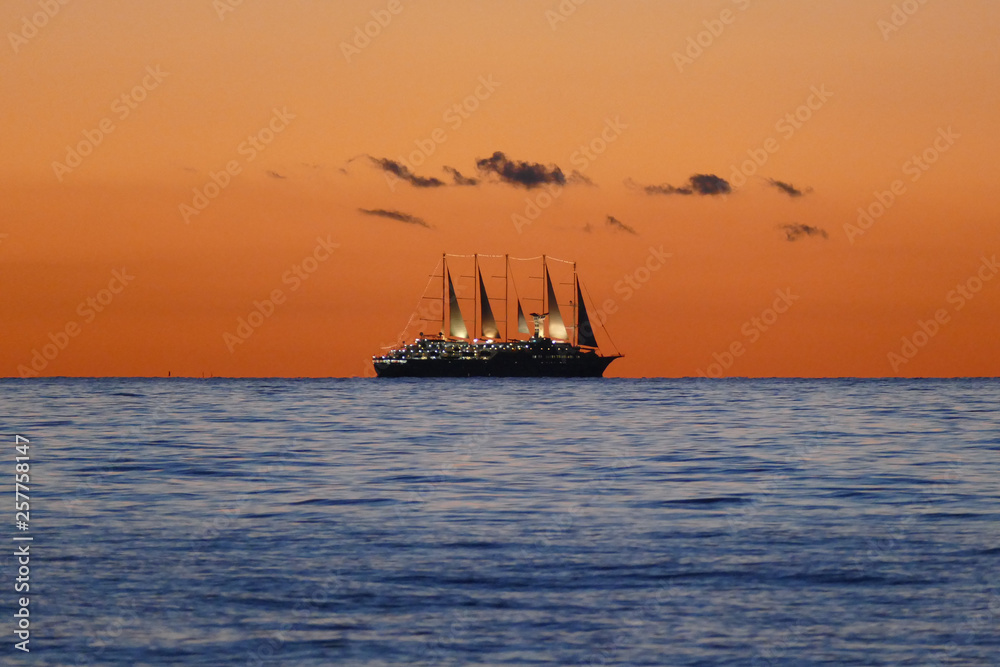 Segelschiff am Horizont bei Sonnenuntergang