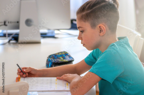 Fotografía stylish trendy child boy schoolboy at the desk doing homework