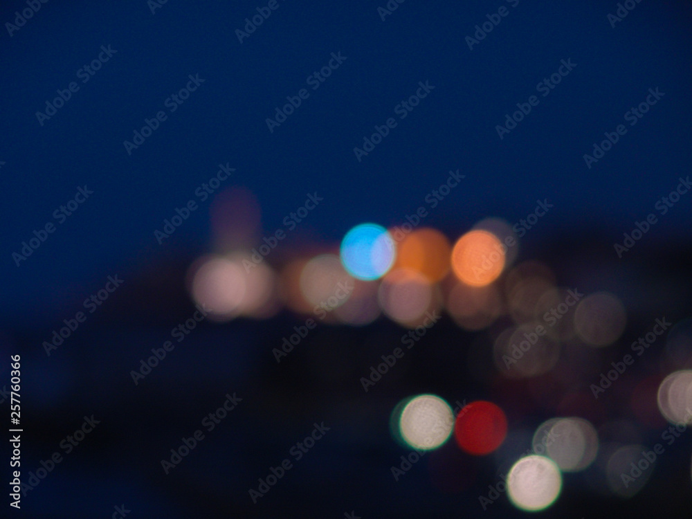 Night city lights bokeh of defocused vivid colorful circles of light in blue hour - obrazy, fototapety, plakaty 