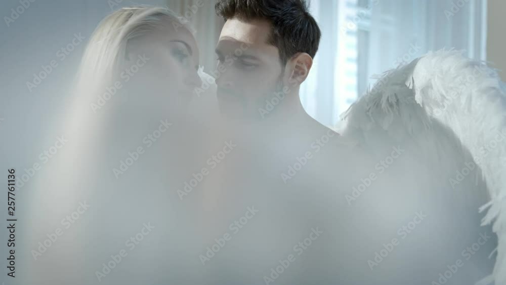 Conceptual footage of an angel protecting a sensual blond woman