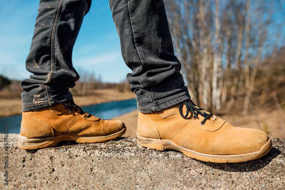 Yellow boots with thick soles for hard work and walking, man in shoes outdoors