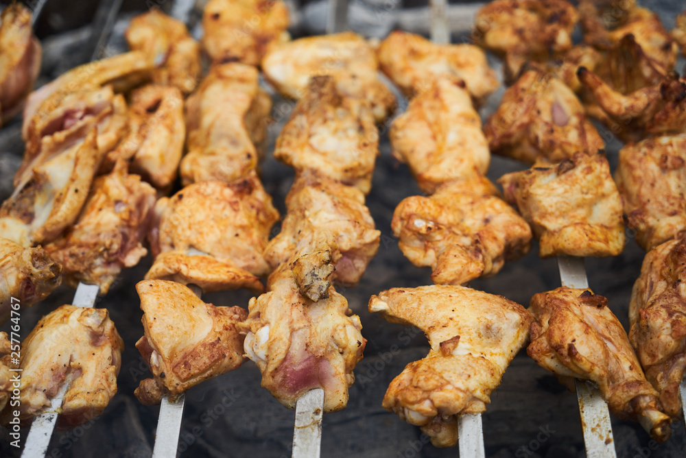 Roasted chicken wings kebab on skewers, close-up, outdoors. Roasted chicken wings kebab on skewers, close-up, outdoors.