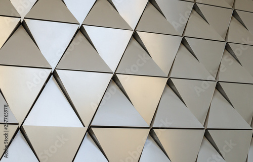 Futuristic Wall of relief metallic triangles. 3d geometric background.