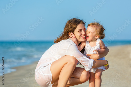 Portrait of mother and little daughter on the sea beach in Greece