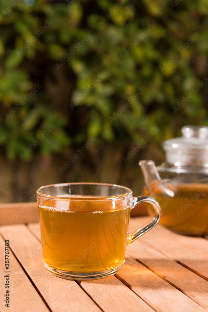 Tasty herbal tea in glass teapot on table, summer leisure Tasty herbal tea in glass teapot on table, summer leisure