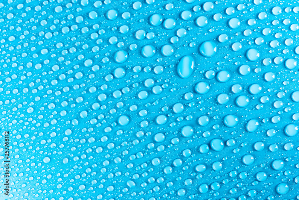 Droplets of water on a blue, matte background illuminated with a delicate light. Droplets of water on a blue, matte background illuminated with a delicate light.