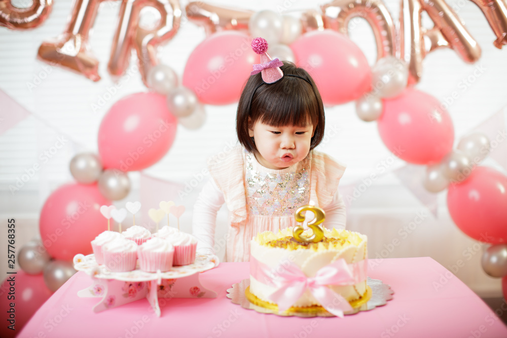 Fototapeta premium toddler girl celebrating her third birthday at home