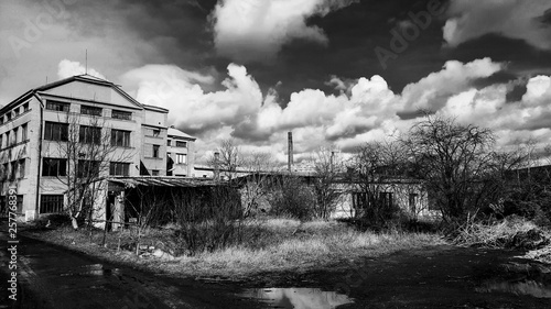 Abandoned old factory building under the cloudy dramatic sky. Symbol of economic depressions. Czech Republic, Velim city.