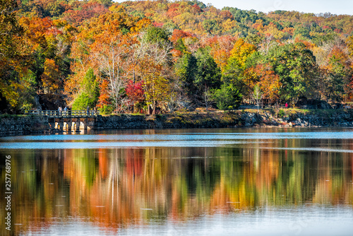 Great Falls trees reflection during autumn in Maryland colorful yellow orange leaves foliage by famous Billy Goat Trail people walking hiking on bridge photo