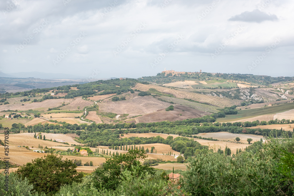 Pienza town in distance and Italy Val D'Orcia countryside in Tuscany with hilltop small town village high angle