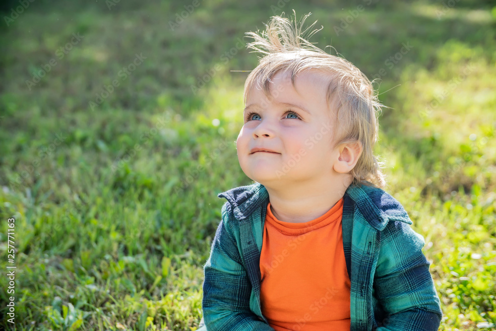 little blond boy on a green grass background on a Sunny day little blond boy on a green grass background on a Sunny day