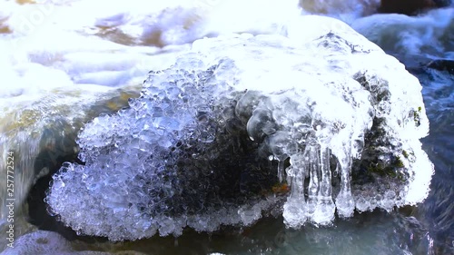 Rock covered with ice in flowing water