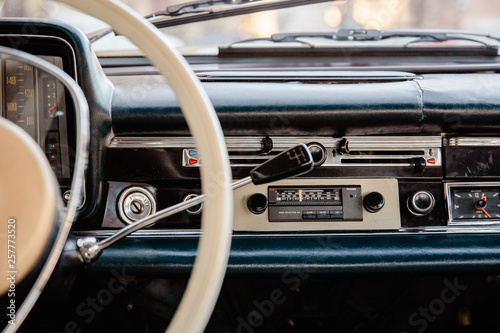 Retro styled image of an old car radio and dashboard inside a classic car © dissx