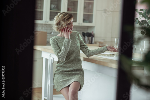 Elegant girlfriend calling her man while staying alone at apartment